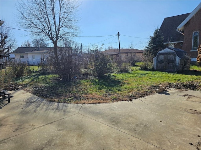 view of yard featuring a storage shed and a patio