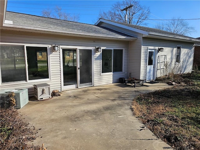 rear view of property with cooling unit and a patio area