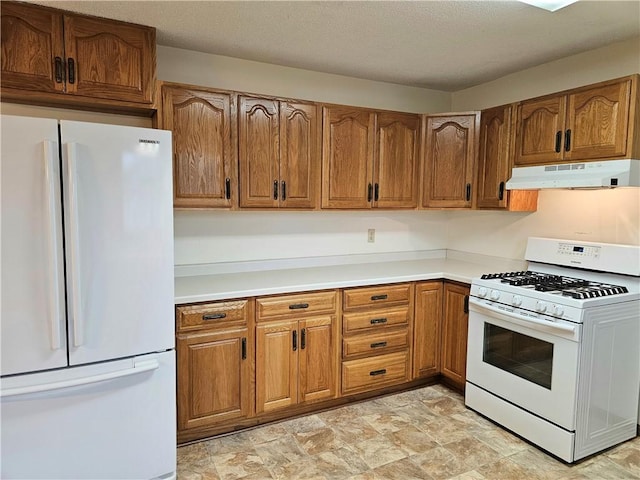 kitchen with a textured ceiling and white appliances