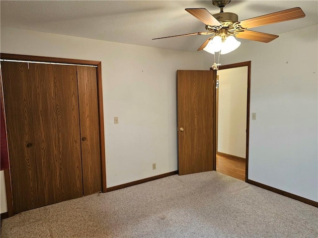 unfurnished bedroom featuring a textured ceiling, ceiling fan, light carpet, and a closet