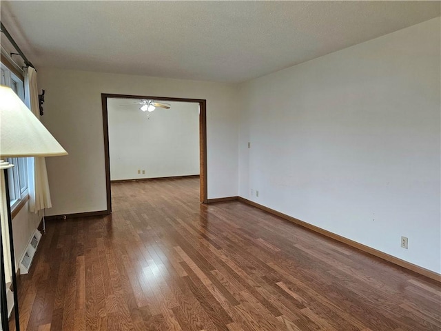 empty room featuring a textured ceiling, dark hardwood / wood-style flooring, and ceiling fan