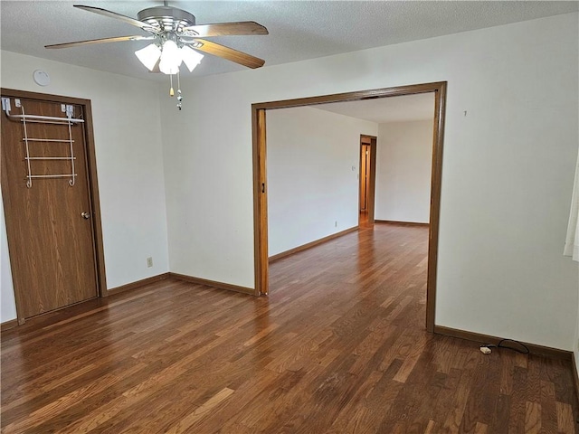 unfurnished room featuring a textured ceiling, ceiling fan, and dark wood-type flooring