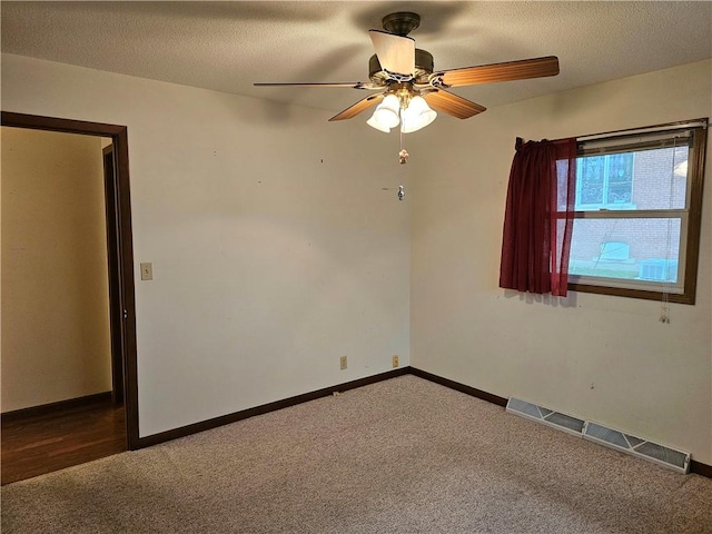 carpeted empty room with ceiling fan and a textured ceiling