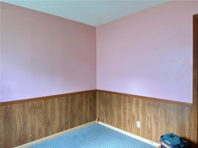 607 E Jefferson Ave, Casey, IL 62420 - empty room featuring wainscoting, carpet floors, and wood walls