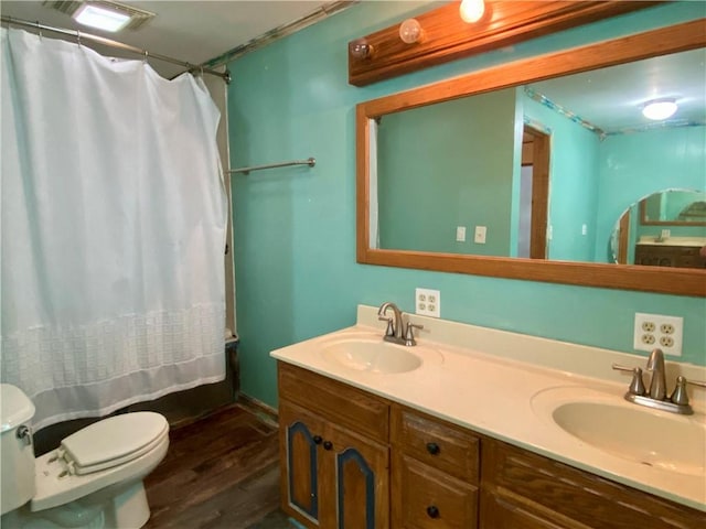607 E Jefferson Ave, Casey, IL 62420 - full bathroom featuring toilet, wood finished floors, double vanity, and shower / bath combination with curtain