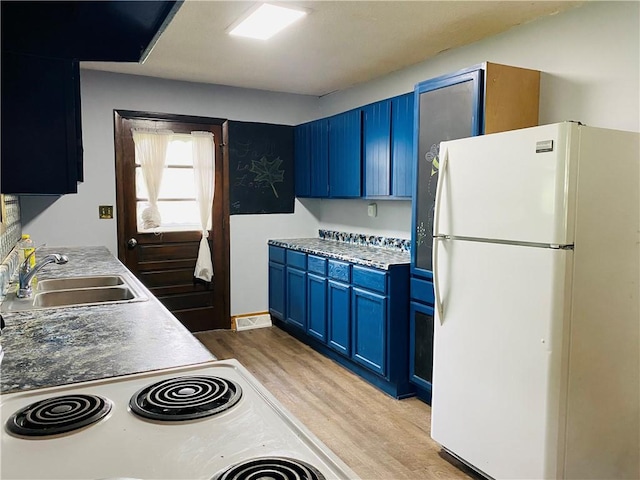 607 E Jefferson Ave, Casey, IL 62420 - kitchen with freestanding refrigerator, blue cabinetry, light wood-type flooring, a sink, and stove