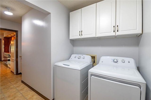 2008 Arthur Ave, Charleston, IL 61920 - laundry room with washer and clothes dryer, a textured ceiling, cabinet space, and light tile patterned flooring