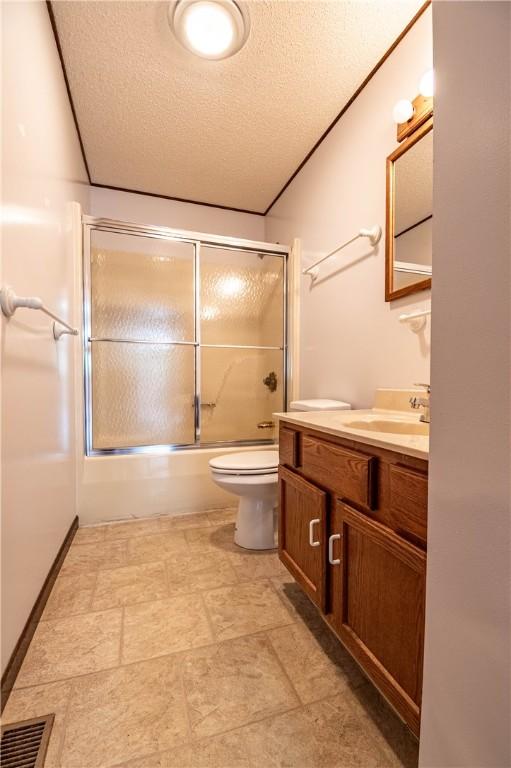 2008 Arthur Ave, Charleston, IL 61920 - bathroom with a textured ceiling, vanity, and shower / bath combination with glass door