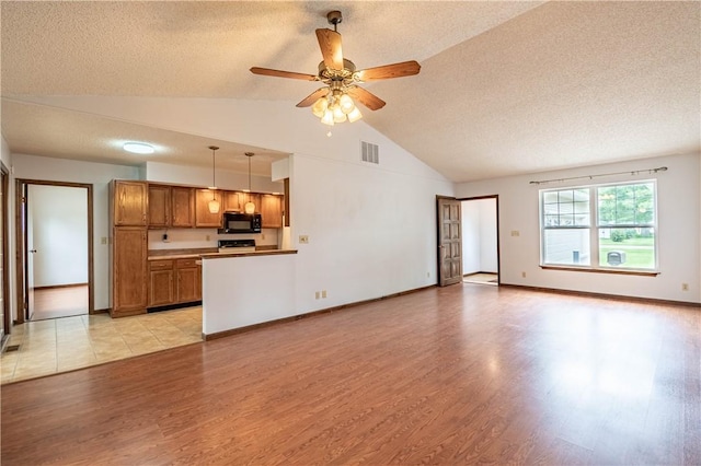 2008 Arthur Ave, Charleston, IL 61920 - unfurnished living room with a textured ceiling, light wood-style flooring, a ceiling fan, and high vaulted ceiling
