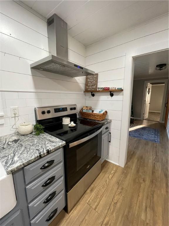 510 S 5th St, Marshall, IL 62441 - kitchen with stainless steel range with electric stovetop, extractor fan, gray cabinets, light wood-type flooring, and decorative backsplash