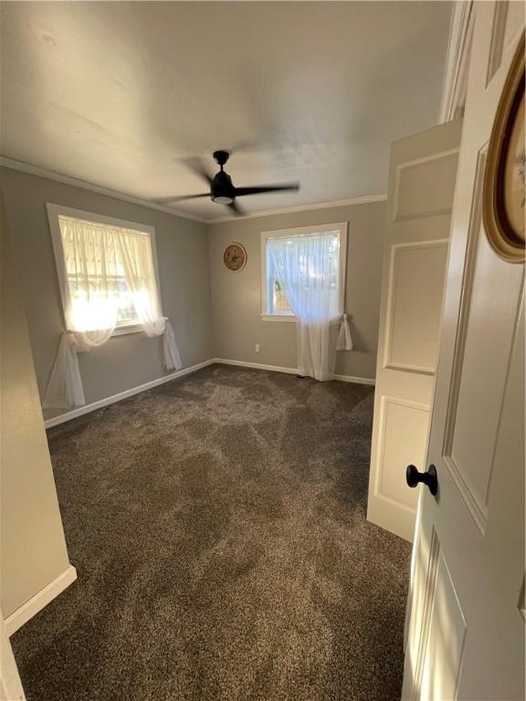 510 S 5th St, Marshall, IL 62441 - empty room with plenty of natural light, a ceiling fan, dark carpet, and ornamental molding