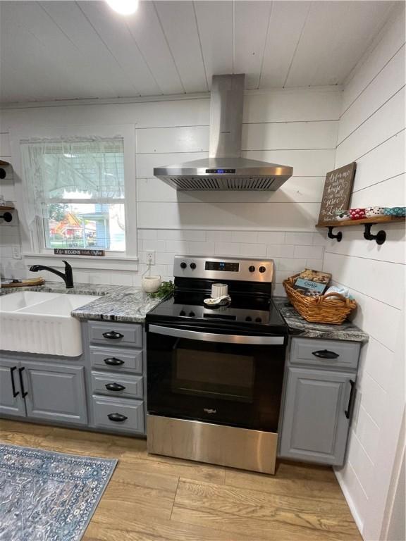510 S 5th St, Marshall, IL 62441 - kitchen with stainless steel range with electric cooktop, wall chimney range hood, gray cabinets, light wood finished floors, and wooden ceiling