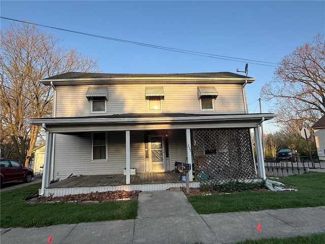 traditional-style house with covered porch and fence