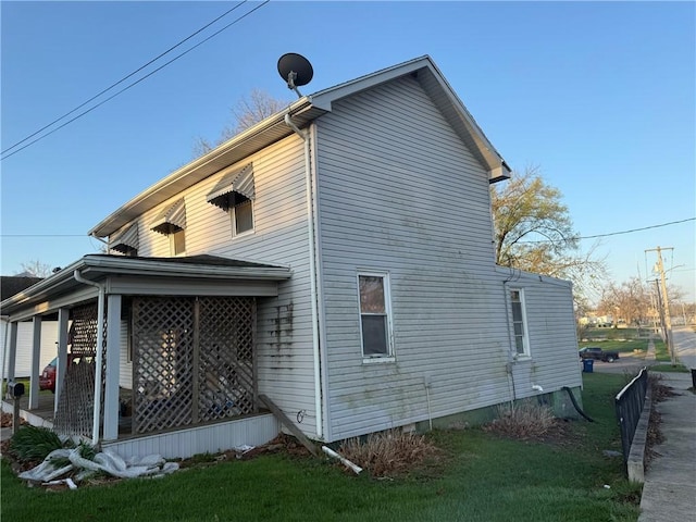view of side of property with a lawn and crawl space