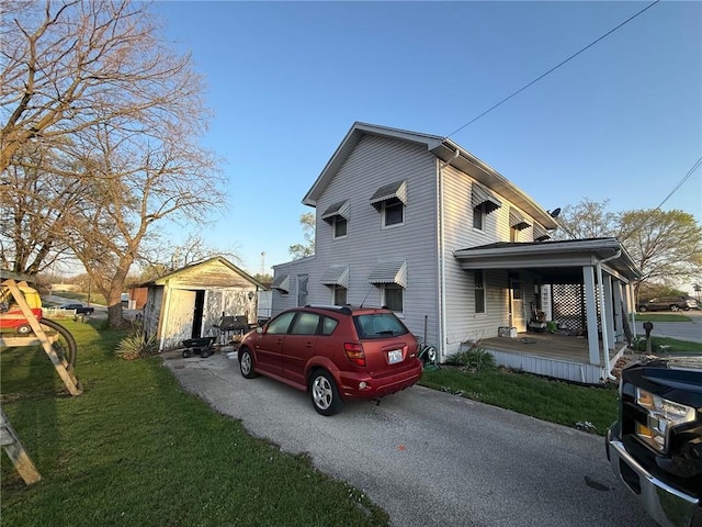 view of property exterior featuring an outdoor structure, a yard, and a storage unit