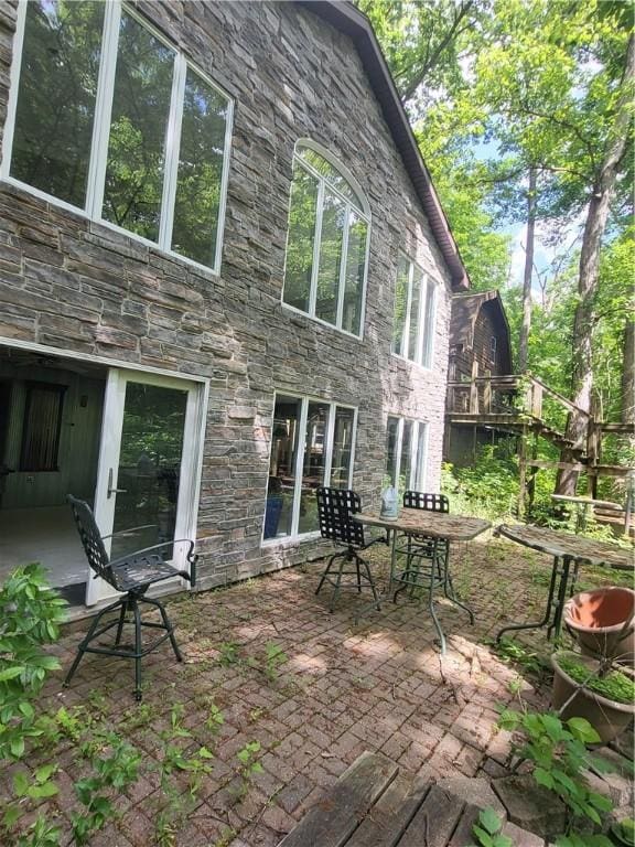 3848 Cahokia Ln, Charleston, IL 61920 - rear view of house with stone siding, a patio area, and outdoor dining area