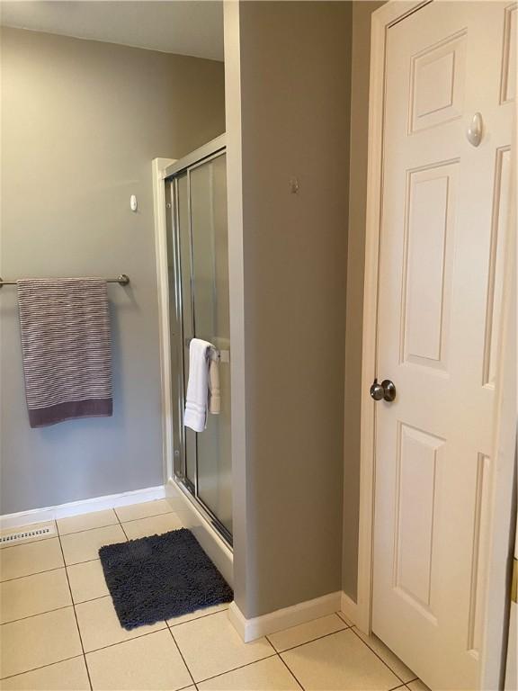 15 Fairfield Ln, Charleston, IL 61920 - full bathroom with tile patterned flooring, a shower stall, and baseboards