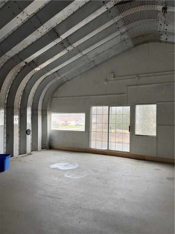 miscellaneous room featuring high vaulted ceiling and concrete floors