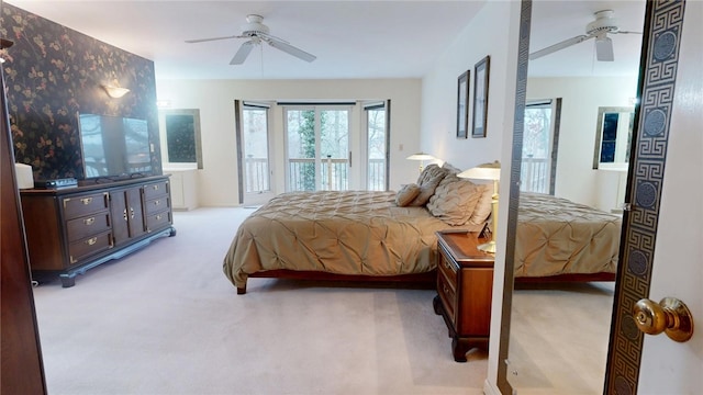 bedroom with light colored carpet, access to exterior, and ceiling fan