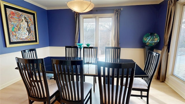 dining room with ornamental molding and light hardwood / wood-style floors