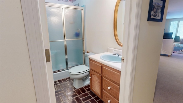 bathroom featuring vanity, an enclosed shower, and toilet