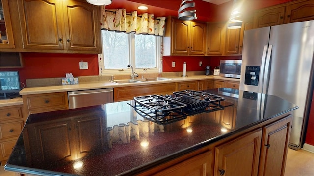 kitchen featuring sink, stainless steel appliances, and dark stone counters