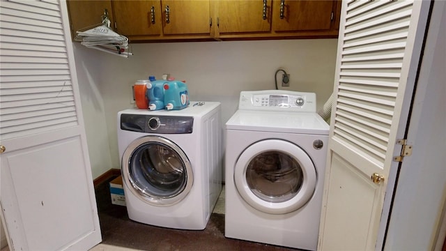 washroom featuring washing machine and dryer and cabinets