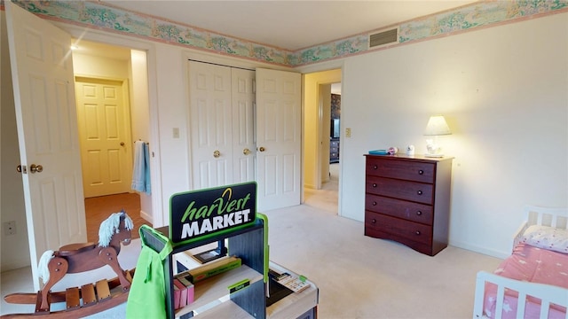 bedroom featuring light colored carpet and a closet