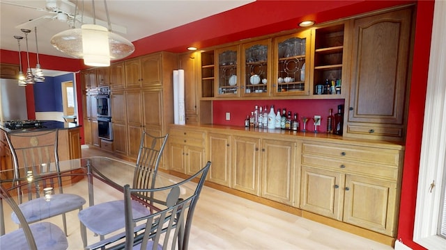 kitchen featuring pendant lighting, appliances with stainless steel finishes, and light hardwood / wood-style flooring