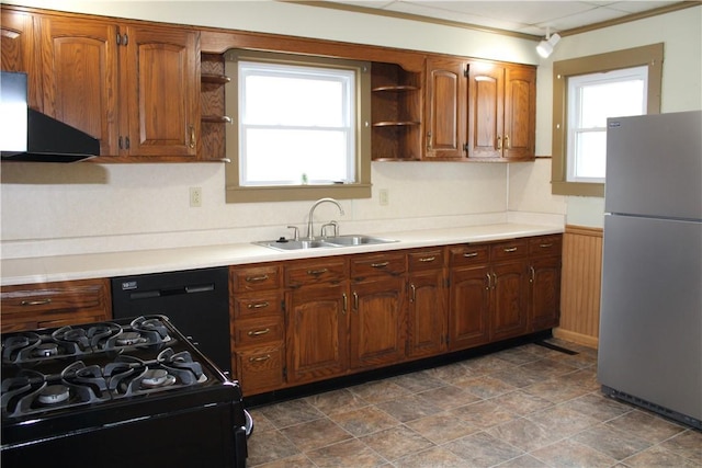 kitchen with sink, exhaust hood, and black appliances