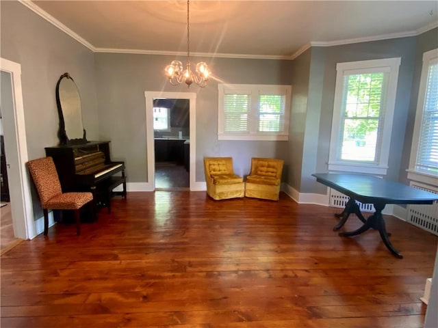401 E Fourth St, Pana, IL 62557 - sitting room featuring wood-type flooring, a chandelier, ornamental molding, radiator heating unit, and baseboards