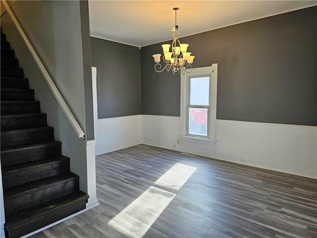 unfurnished room featuring a chandelier and dark hardwood / wood-style flooring