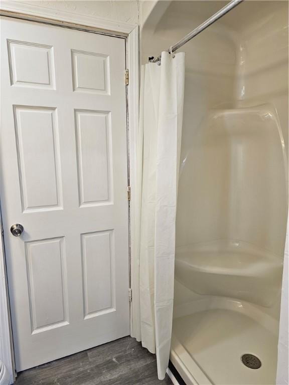 bathroom featuring hardwood / wood-style flooring and walk in shower