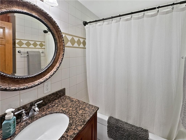 full bath featuring shower / tub combo with curtain, tile walls, vanity, and tasteful backsplash