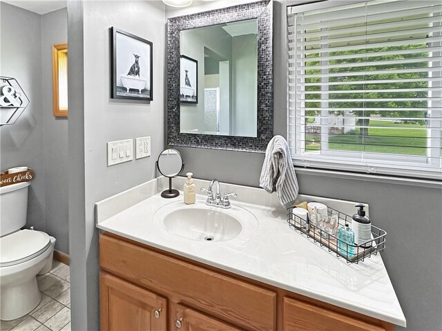 bathroom with tile patterned floors, toilet, vanity, and baseboards