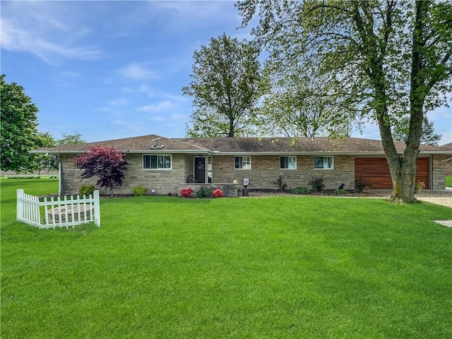 view of front of home featuring stone siding, a front yard, and a garage