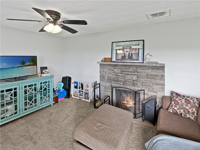 living area featuring carpet floors, ceiling fan, and a fireplace
