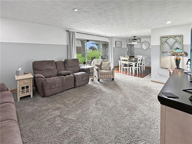 living area featuring carpet floors, baseboards, recessed lighting, and a textured ceiling