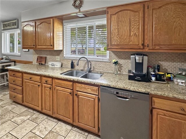 kitchen featuring dishwasher, a sink, and tasteful backsplash