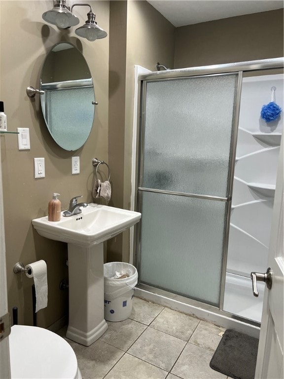 bathroom with tile patterned flooring, an enclosed shower, and toilet