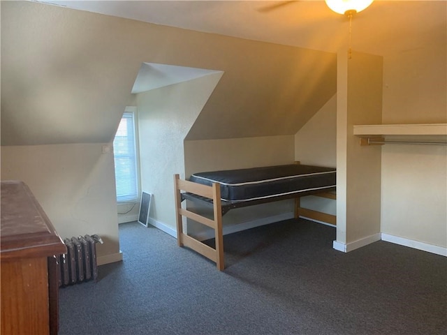 carpeted bedroom featuring radiator heating unit and lofted ceiling