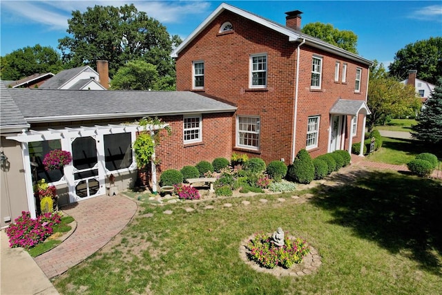 rear view of house featuring a pergola and a lawn