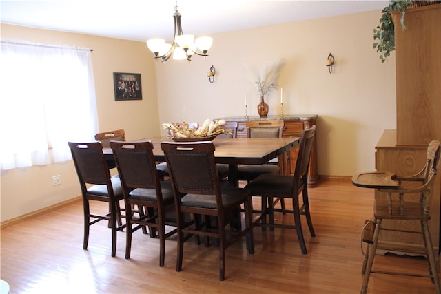 dining space with a chandelier and light hardwood / wood-style flooring