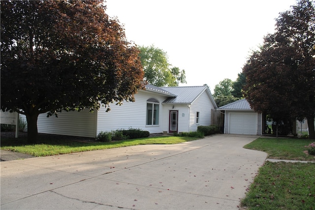 view of front of house with an outbuilding, a garage, and a front lawn