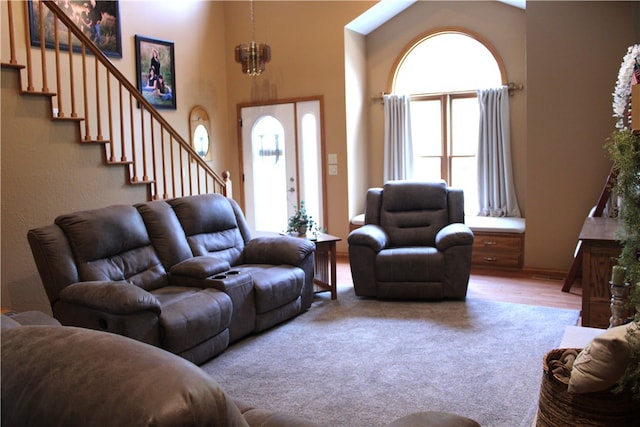 living room featuring hardwood / wood-style floors, high vaulted ceiling, and a chandelier