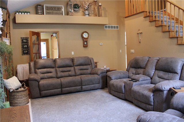 carpeted living room featuring high vaulted ceiling