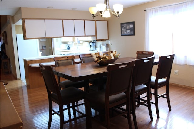 dining room with an inviting chandelier and light hardwood / wood-style flooring