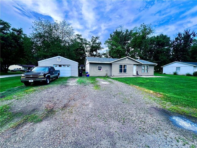 100 Chaparral St, Watson, IL 62473 - view of front facade with a garage, an outbuilding, driveway, and a front yard