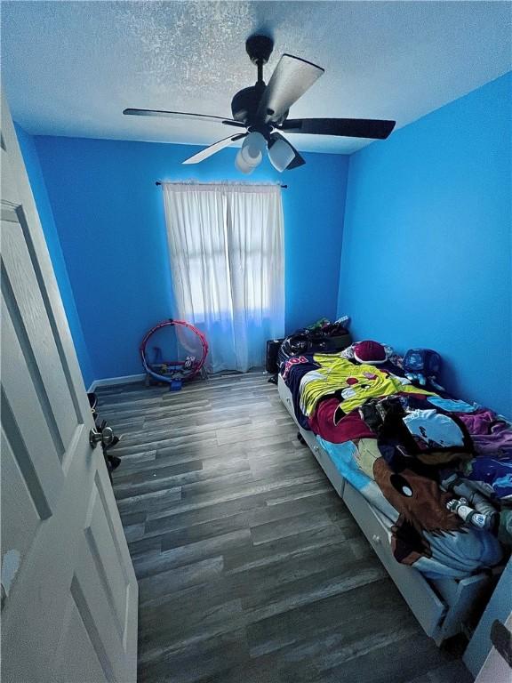 100 Chaparral St, Watson, IL 62473 - unfurnished bedroom with a textured ceiling, wood finished floors, and ceiling fan