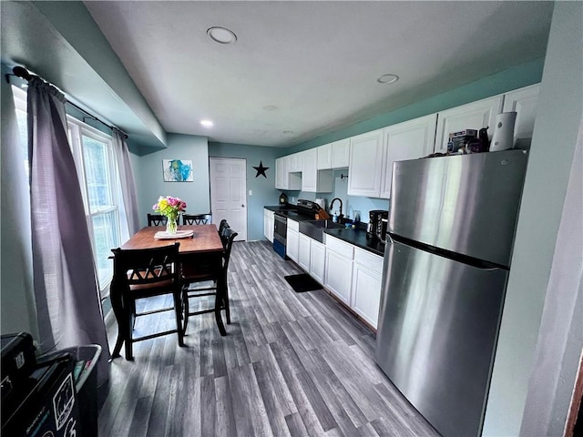 100 Chaparral St, Watson, IL 62473 - kitchen with freestanding refrigerator, dark countertops, white cabinets, dark wood-type flooring, and recessed lighting